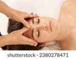 woman receiving a facial massage on the forehead area