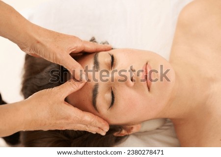 woman receiving a facial massage on the forehead area