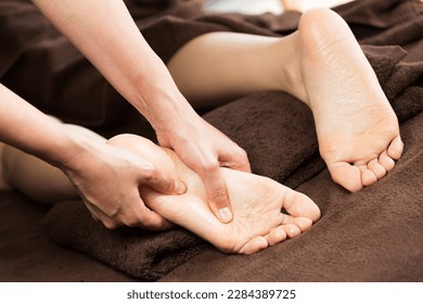 The woman is receiving a foot massage. - Powered by Shutterstock