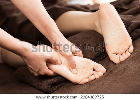 The woman is receiving a foot massage.