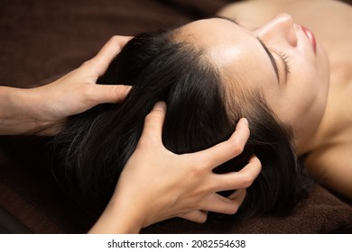 The woman is receiving a head massage. - Powered by Shutterstock