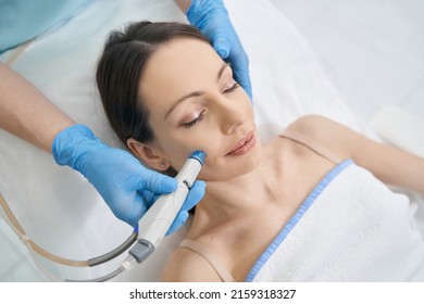 Woman Receiving Hydrafacial Treatment In Beauty Salon