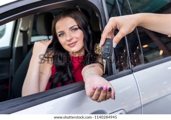 Woman receiving keys from a\
new car