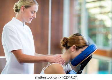 Woman receiving massage in massage chair at spa