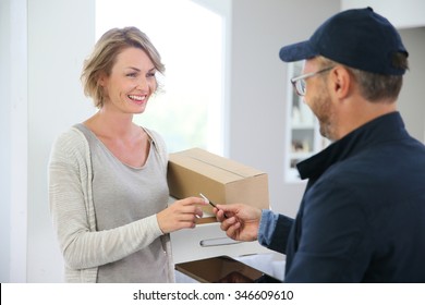 Woman Receiving Package From Delivery Man