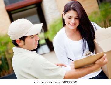 Woman Receiving A Package At Home From A Delivery Guy