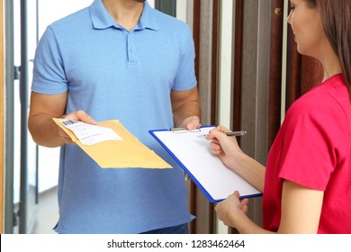 Woman Receiving Padded Envelope From Delivery Service Courier Indoors, Closeup