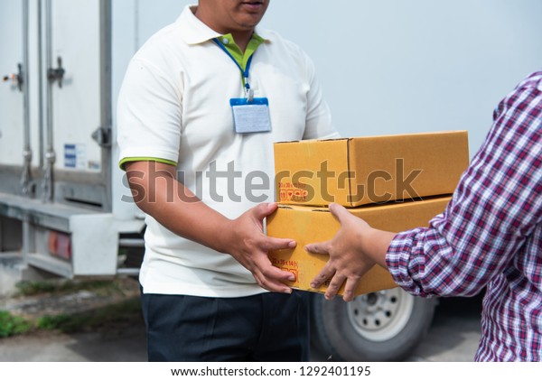 woman\
is receiving a parcel box from the delivery\
staff.