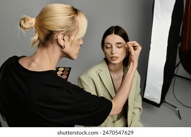 A woman receiving professional makeup application from a skilled artist.