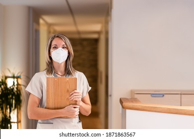 Woman Receptionist Holding Folder With Documents And With Mask In Hospital