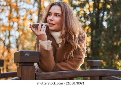 Woman Recording Voice Message At Her Smartphone While Standing