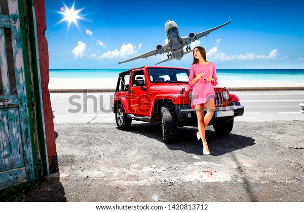 woman with red car and airplane
on summer road. Free space for your decoration. Summer time
