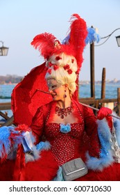 A Woman In A Red Carnival Costume Of Marie Antoinette And A Mask Holds A Red Umbrella On The Embankment In Venice Italy, February 20, 2017