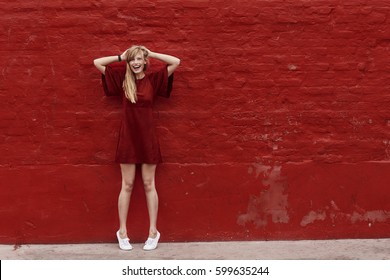 Woman In Red Dress Against Red Wall, Portrait