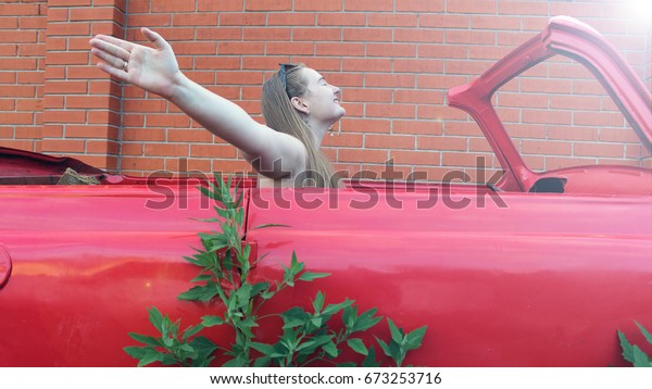 woman in red dress in\
the broken red car