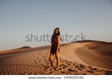 Woman in red dress in the desert dunes