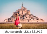 Woman with red dress enjoying view of Le Mont Saint Michel- Normandie in France