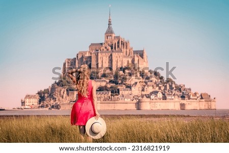 Woman with red dress enjoying view of Le Mont Saint Michel- Normandie in France