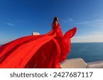 Woman Red Dress, Fashion Model In Long Silk Waving Gown Wings, Flying Fabric in Santorini, Blue dom.