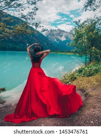 Woman in red dress on blue sky background of mountains