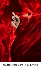 Woman in red dress posing with waving fabric, Girl fantasy dreams concept