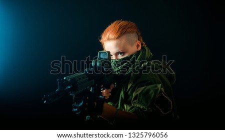 Woman with red hair, hold machinegun and takes aim at the sight. horizontal background
