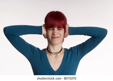 a woman with red hair and turned nose holds ear closed