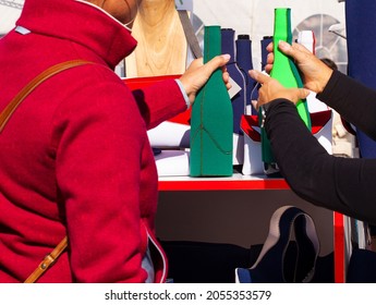 Woman With A Red Jacket Buying A Neoprene Bottle In A Specialized Shop 