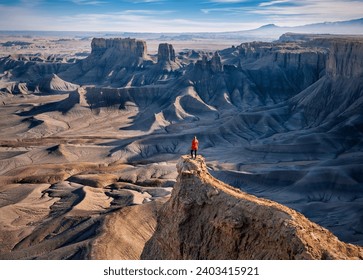 Woman in red jacket on cliff above colorful canyon. Moonscape overlook. Hanksville. Utah. USA - Powered by Shutterstock