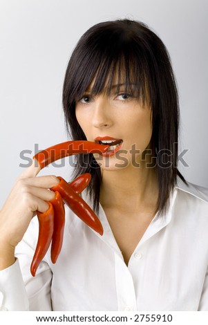 Woman With Red Peppers On Her Fingers. White background in studio.
