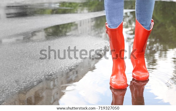 Woman in red rubber boots,\
outdoors