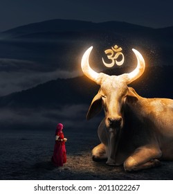 Woman in red sari worships big Holy Cow with glowing horns and Om symbol in Rajasthan, India