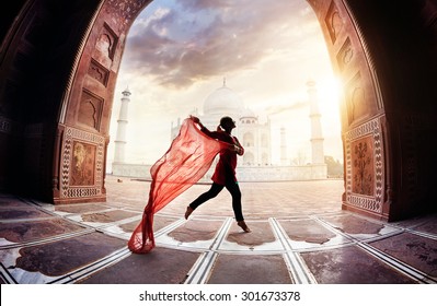 Woman with red scarf dancing near Taj Mahal in Agra, Uttar Pradesh, India - Shutterstock ID 301673378