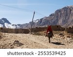 a woman with red scarf riding donkey in Afghanistan