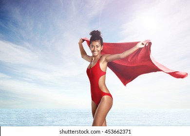 Woman In Red Swimsuit Of Life Guard With Red Towell On A Beach