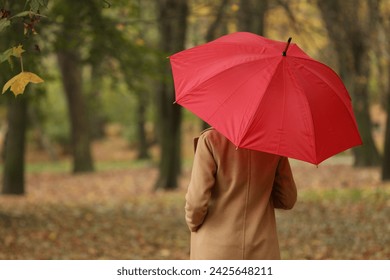 Woman with red umbrella walking in autumn park, back view. Space for text - Powered by Shutterstock