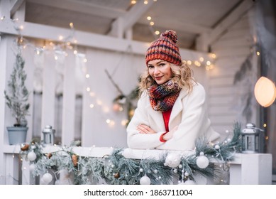 Woman  In Red And White Sit  In Decorated Illuminated Twinkle Lights Glowing Xmas Tree Near House And  Feel Happy