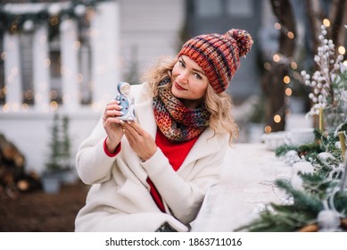 Woman  In Red And White Sit  In Decorated Illuminated Twinkle Lights Glowing Xmas Tree Near House Take A Toy