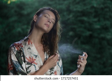 Woman Refreshing With Thermal Water Against Summer Heatwave. Woman Spraying Body Or Hair Mist, Summertime Skincare And Haircare Concept.