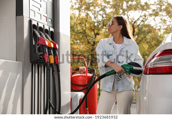Woman refueling\
car at self service gas\
station