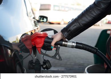Woman refueling her car in a gas station