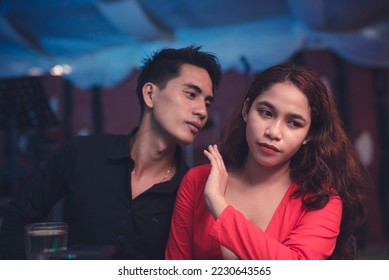 A woman refuses a kiss from an aggressive date. A couple is having a lover's quarrel in a restaurant. Breakup scene. - Shutterstock ID 2230643565