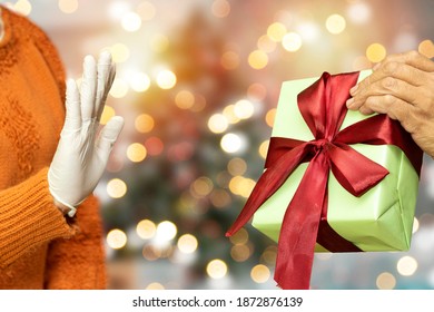 Woman Refusing Christmas Gift Of Her Friends Using Elbow Bump. New Novel Greeting To Avoid The Spread Of Coronavirus