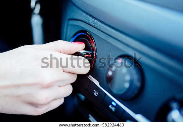 Woman\
regulates heating in her car. Modern car\
interior