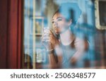 Woman, relax and thinking by window at coffee shop for morning, reflection and daydreaming of future. Calm, peace and owner with idea by glass at cafe for small business, inspiration and store growth