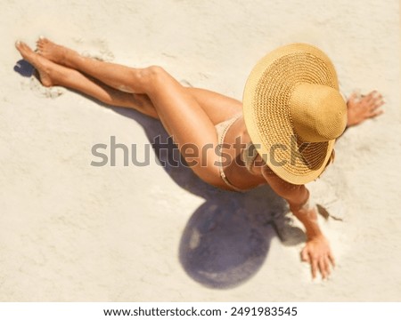 Woman, relax and top view at beach for travel, vacation and tanning in Bali with tanning in bikini. Girl, hat and above outdoor in swimwear for journey, wellness and tropical holiday with sunbathing
