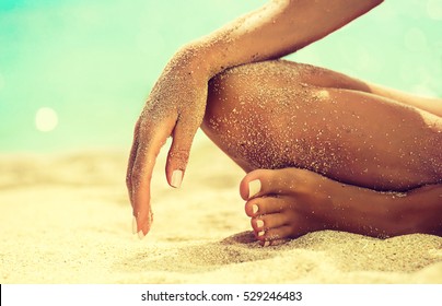 Woman In Relaxation On Tropical Beach with sand , body parts  . Tanned girl in Lotus position,yoga, and meditation 