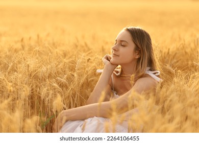 Woman relaxing alone in a field at sunset