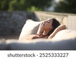 Woman relaxing alone sitting on a couch in a terrace at home