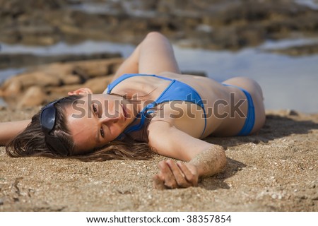 woman relaxing at the beach, lying on sand